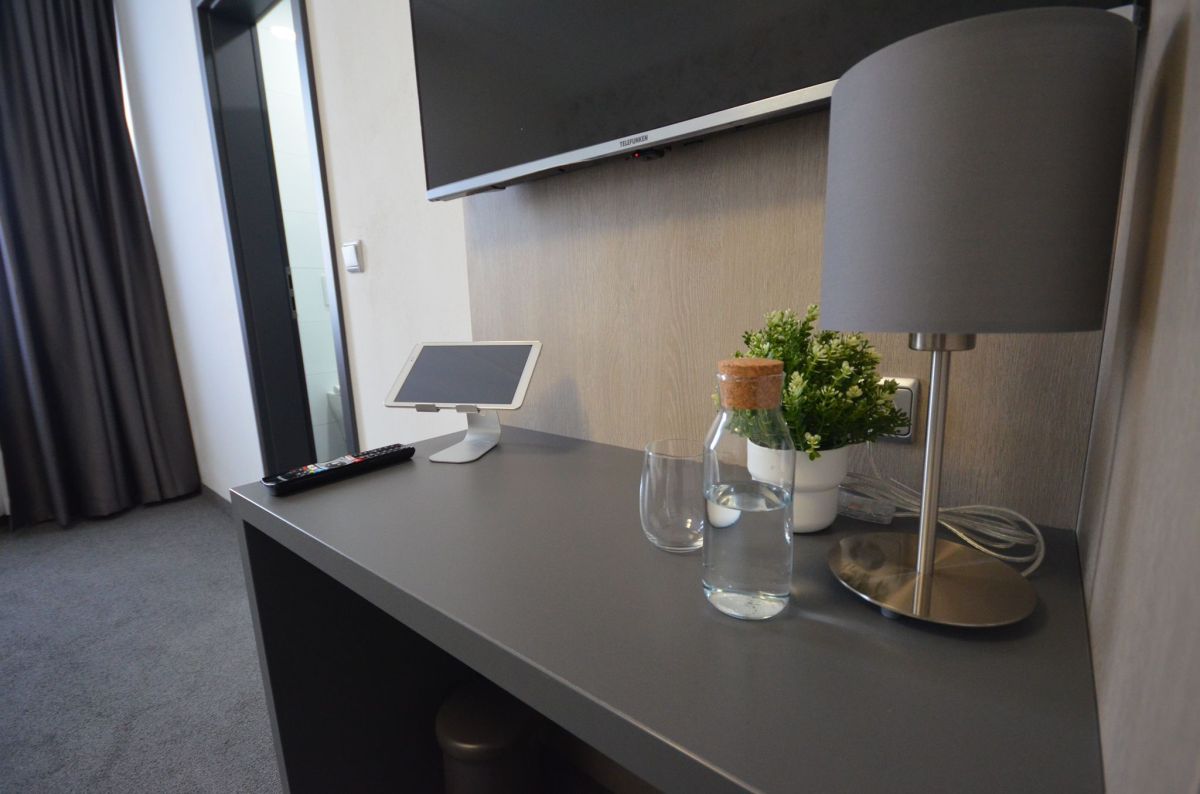 Schreibtisch mit Tablet und Leuchte im Zimmer