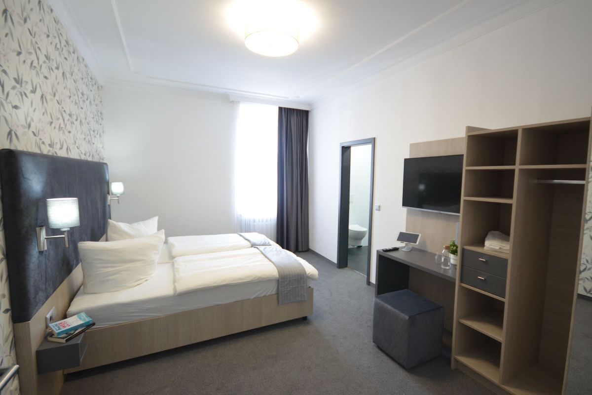 Hotelzimmer mit Boxspringbett und Kleiderschrank